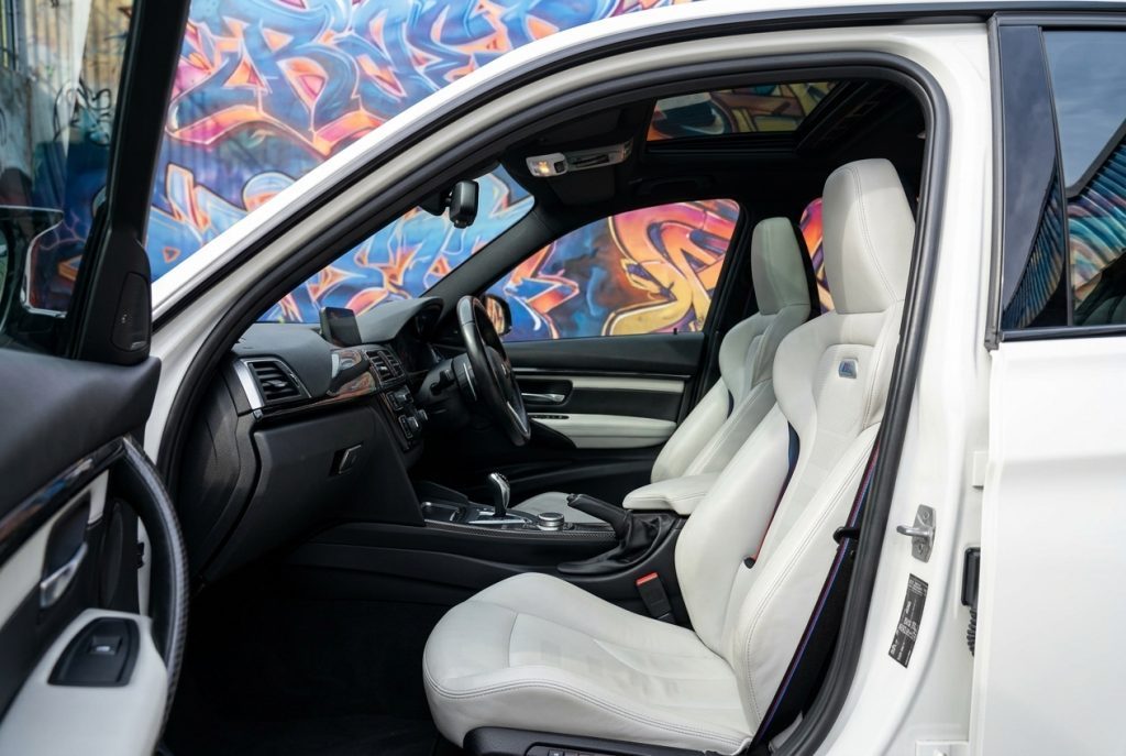 Front seats and dashboard of the white 2016 BMW M3 Competition F80 Stage 1, available for hire in Sydney