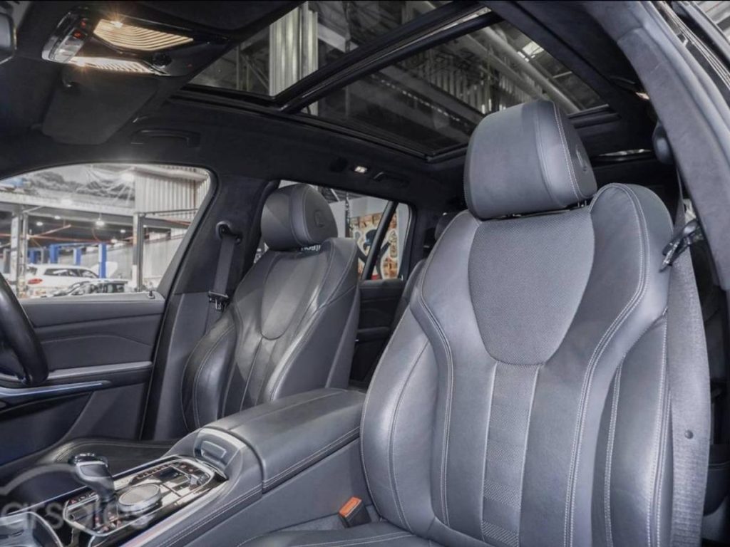 Front seats of the blue 2019 BMW X7 xDrive30d, available for hire in Sydney