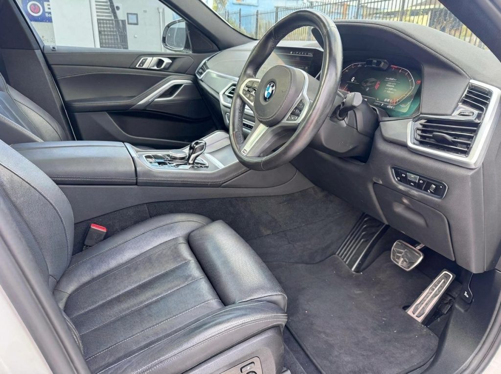 Front seats of the white 2022 BMW X6 xDrive40i M Sport, available for hire in Sydney