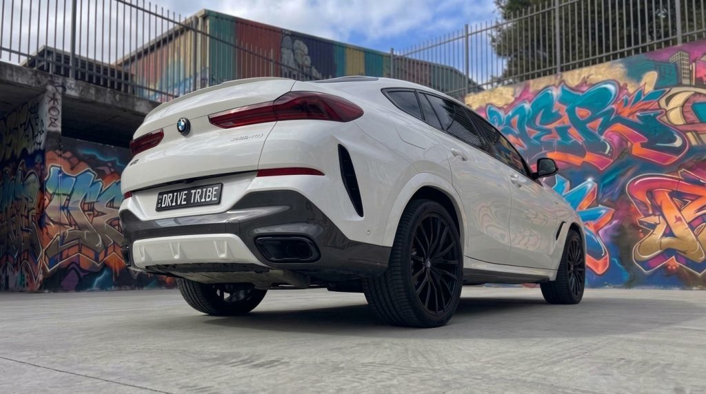 White 2022 BMW X6 xDrive40i M Sport, rear three-quarter view, available for hire in Sydney
