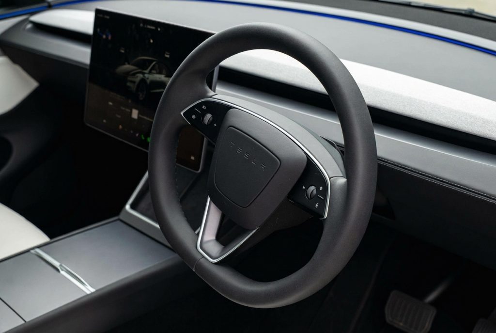 Steering wheel of the silver 2025 Tesla Model Y RWD, available for hire in Sydney