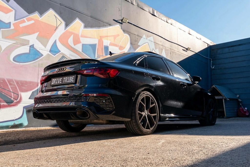 Black 2022 Audi RS 3 Sportback, rear three-quarter view, available for hire in Sydney